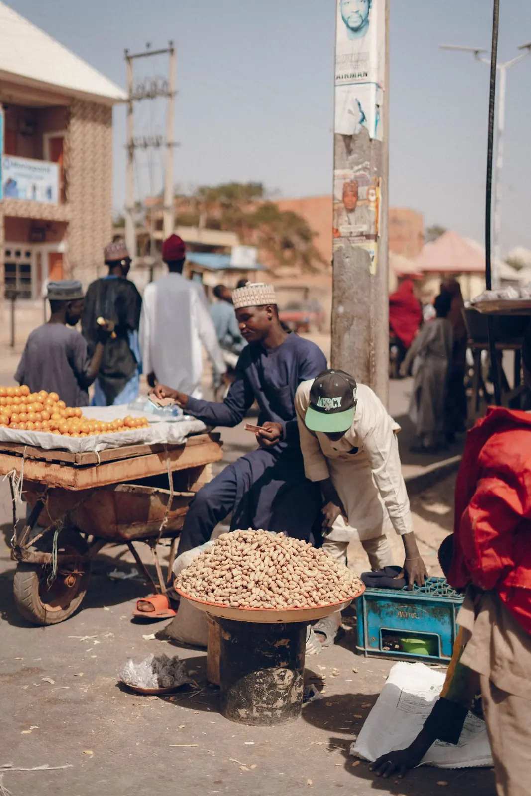 Street vendor with a stall of goods beside a busy road