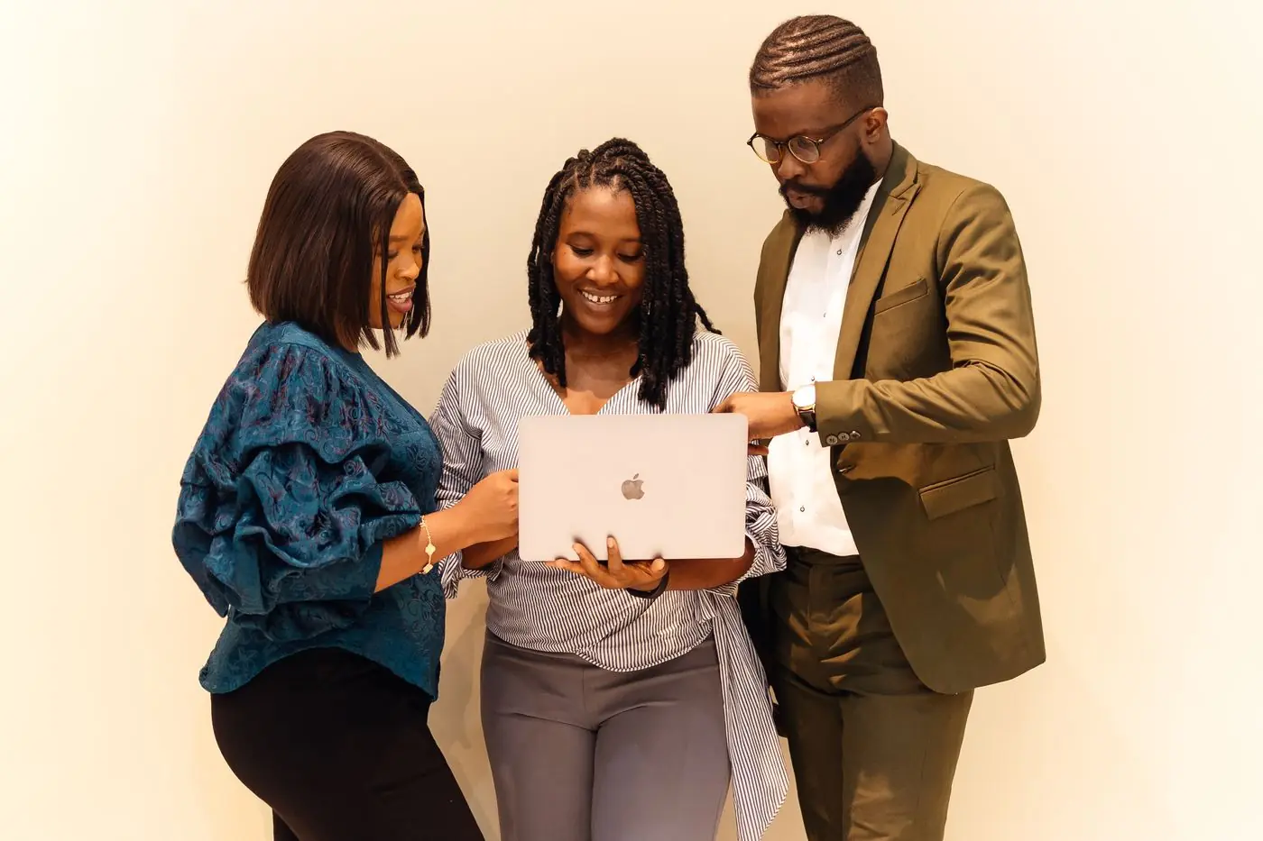 Three colleagues around a laptop